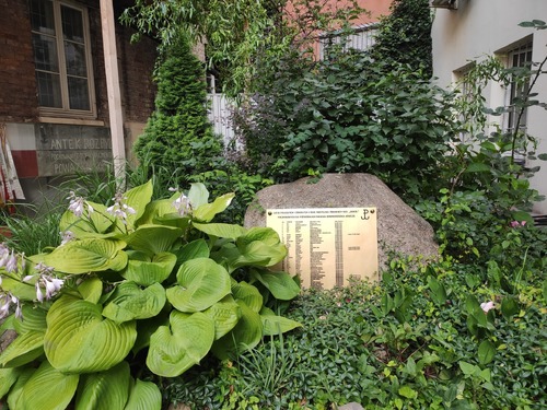 Miejsce pamięci w oficynie kamienicy przy ul. Brackiej 5. Na pierwszym planie tablica poświęcona poległym żołnierzom batalionu „Sokół”, w głębi, na ścianie budynku po lewej stronie – oryginalny napis dotyczący miejsca pochówku Antoniego Godlewskiego. Warszawa, 2023 r. (fot. I. Siwińska)