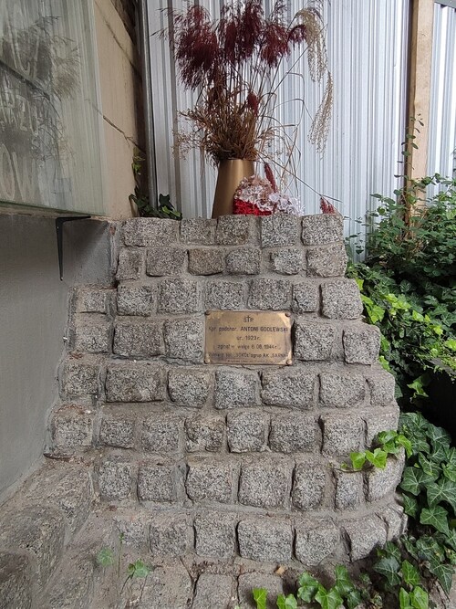 Symboliczny szaniec z kostki granitowej, z tabliczką upamiętniającą Antoniego Godlewskiego „Antka Rozpylacza”, w oficynie kamienicy przy ul. Brackiej 5, tuż obok oryginalnego napisu informującego o miejscu jego powojennego pochówku. Warszawa, 2023 r. (fot. I. Siwińska)
