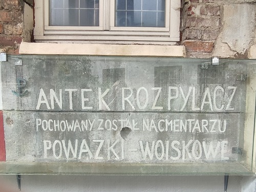 Zabezpieczony ochronną płytą napis wykonany w 1945 r. przez matkę „Antka Rozpylacza”, Anielę Godlewską, w oficynie kamienicy przy ul. Brackiej 5 – w pobliżu miejsca pierwotnego pochówku syna w tym samym podwórzu. Warszawa, 2023 r. (fot. I. Siwińska)