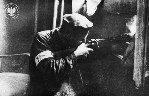 Powstaniec z opaską na ramieniu na ulicy Królewskiej. Autor: Jerzy Tomaszewski (fot. z zasobu IPN)