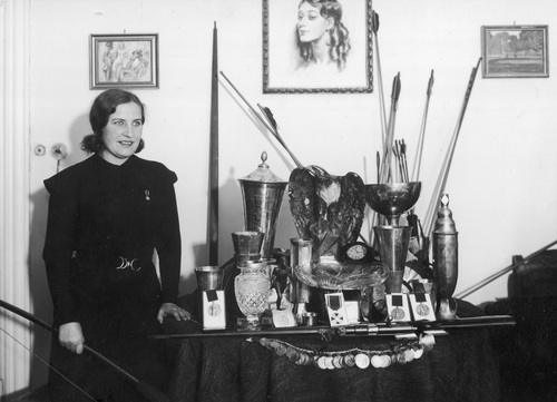 Łuczniczka Janina Kurkowska-Spychajowa prezentuje zdobyte trofea sportowe. Zdjęcie zostało wykonane w 1934 r. Za pięć lat, na kilka miesięcy przed wybuchem wojny, mistrzyni odda sportowe pamiątki, by zasilić budżet polskiego lotnictwa (Fot. NAC)