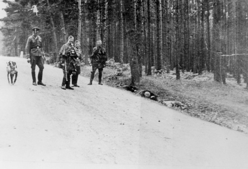 Niemcy pozujący do zdjęcia przy zatrzymaniu Polaków (leżący w rowie) w trakcie pacyfikacji Michniowa (fot. z zasobu AIPN)