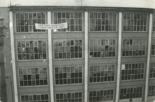 Baner z hasłem: „Zdrowie i Oświata – trzymajcie się”, wywieszony naprzeciwko okien sali 920 Urzędu Wojewódzkiego. Fot. Kolekcja Zofii Madej, z zasobu AIPN