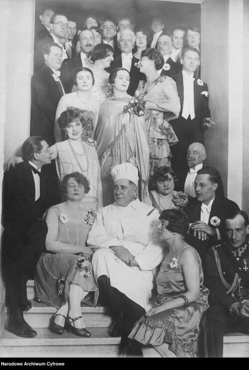 Uczestnicy balu na schodach. Wśród zebranych widoczni m.in.: Ferdynand Antoni Ossendowski (pośrodku, w stroju kucharza), ppłk Józef Beck (w dolnym prawym rogu), Julian Tuwim (stojący po prawej z papierosem w dłoni), Jan Lechoń (w górnym lewym rogu w okularach). Luty, 1927 r. Autor nieznany. Fot. Narodowe Archiwum Cyfrowe