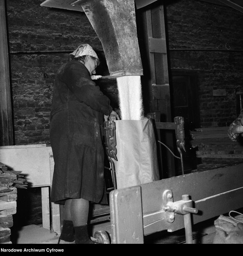 A woman operates a device pouring sugar into a bag, 1968. Photo: National Digital Archives