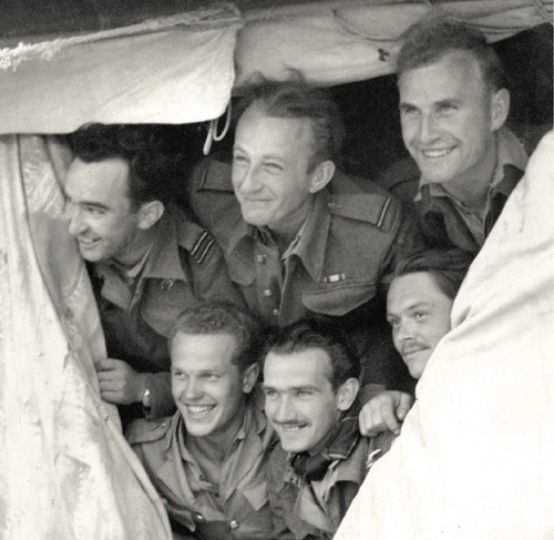 W wejściu do jednego z namiotów wesoło pozuje szóstka pilotów, którzy w starciu 20 IV 1943 r. uzyskali zestrzelenie sześciu samolotów wroga bez strat własnych. U góry, od lewej: kpt. Wacław Król, por. Bohdan Arct i st. sierż. Władysław Majchrzyk, poniżej, od lewej: st. sierż. Mieczysław Popek, por. Ludwik Martel i por. Władysław Drecki
