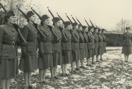 Ochotniczki z jednostki pomocniczej Polskich Sił Zbrojnych podczas musztry z bronią w obozie szkoleniowym prawdopodobnie w Wielkiej Brytanii. Odbitka rozpowszechniana przez komórki propagandy Rządu RP na uchodźstwie, pochodząca z kolekcji Teresy Mellerowicz-Gelli (fot. z zasobu AIPN)