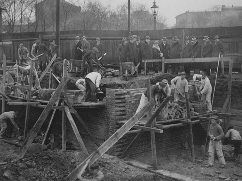 Członkowie Komitetu budowy Domu Żołnierza Polskiego w Poznaniu z wizytą na miejscu prac, przy zbiegu ulic Ratajczaka i Wałów Jagiellończyka, luty 1936 r. (fot. z zasobu NAC)