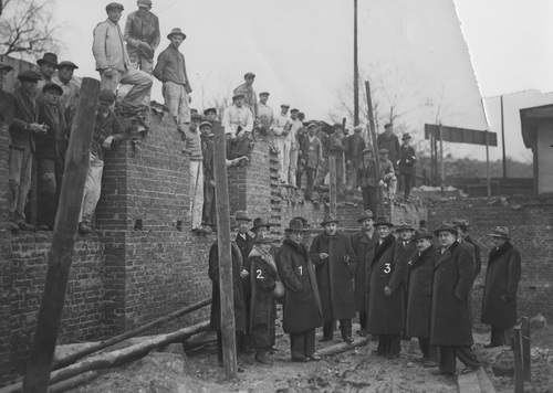 Członkowie Komitetu budowy Domu Żołnierza Polskiego w Poznaniu z wizytą na miejscu prac, przy zbiegu ulic Ratajczaka i Wałów Jagiellończyka, luty 1936 r. (fot. z zasobu NAC)