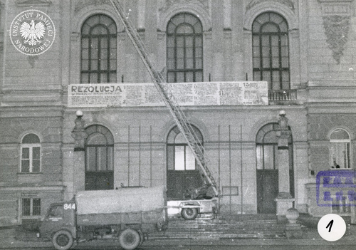 Samochód straży pożarnej z drabiną, częściowo zasłonięty przez ciężarówkę, wykorzystany przy zdejmowaniu transparentów z Gmachu Głównego PW, 23 marca 1968 r. Zdjęcie wykonane przez por. M. Wawrzyniaka i por. R. Końskiego, funkcjonariuszy z Laboratorium Kryminalistyki Komendy MO m.st. Warszawy (fot. z zasobu IPN)