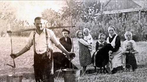 Kolaż dwóch zdjęć. Od lewej: Józef Ulma, Władzio, Stasia trzymająca na rękach Marysię, Franio, Wiktoria będąca w ciąży, Basia, a przed nią Antoś. W oddali po prawej chata Ulmów, gdzie na strychu ukrywali się Gołda Grünfeld, Lea Didner z córeczką Reszlą oraz Saul, Baruch, Mechel, Joachim i Mojżesz Goldmanowie. Stopklatka z prezentacji multimedialnej do wystawy „»Błogosławieni Sprawiedliwi, albowiem…« Opowieść o Rodzinie Ulmów” (wykonanie kompozycji: Kłaput Project w 2023 r.)