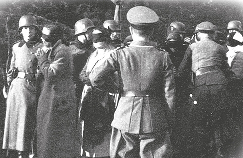 Niemcy prowadzący polskich więźniów z zawiązanymi oczami na miejsce straceń w Palmirach (fot. z zasobu AIPN)