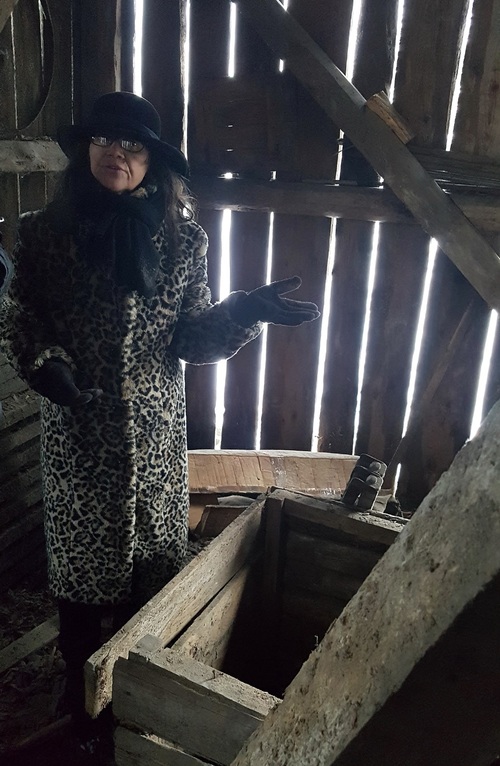 Joanna Bąk at the uncovered entrance to a small room built under the floor of the barn. Photo from the author’s collection