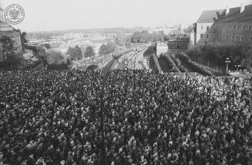 Ludzie zebrani na pl. Zamkowym po zamachu na papieża Jana Pawła II. Widok w kierunku Wisły i Trasy W-Z. Warszawa, maj 1981 r. Fot. Jan Hausbrandt (fot. z zasobu AIPN)