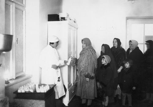 Higienistka wydaje grupie matek mleko dla dzieci w Stacji Opieki nad Matką i Dzieckiem przy Powiatowym Ośrodku Zdrowia w Jarosławiu, 1930 (fot. z zasobu NAC)