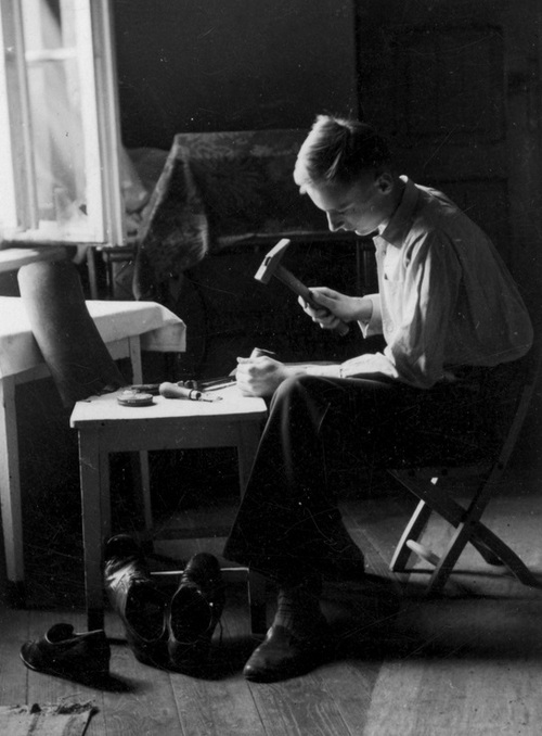 Szewc podczas naprawiania butów, 1942 r. (fot. z zasobu NAC)