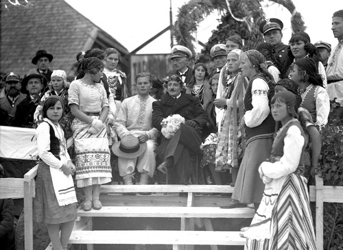 Starosta dziśnieński Ludwik Muzyczka (w środku) i starosta dożynkowy, w otoczeniu delegacji młodzieży z okolicznych gmin podczas dożynek w Głębokiem, 1934 r. (fot. z zasobu NAC)