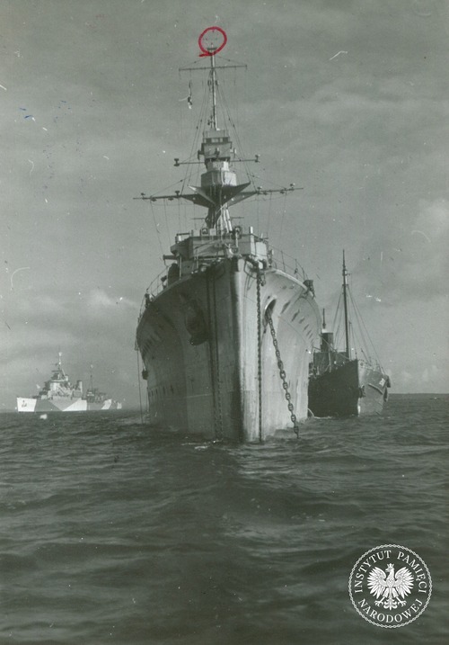 ORP Dragon – widok od strony dziobu, marzec 1944 r. „Okręt owszem imponujący” jak go opisał służący wtedy na krążowniku Tomasz Łubieński. Czerwone kółko wokół anteny radaru to znak ingerencji wojskowego cenzora, który wskazywał, co należy usunąć ze zdjęcia przed publikacją. Kopia cyfrowa fotografii pozyskana ze zbiorów Stowarzyszenia Weteranów Armii Polskiej w Ameryce (fot. z zasobu IPN)