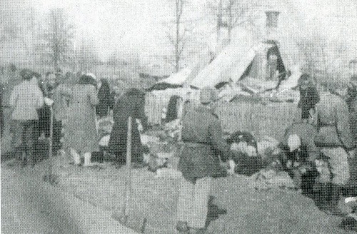 Zamordowani i ocalali mieszkańcy na tle szczątków Domu Ludowego w Lipnikach (fot. ze zbiorów Leona Popka)