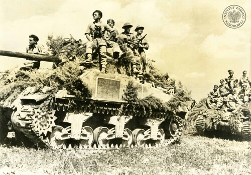 Walki Drugiego Korpusu Polskiego na froncie włoskim. Na zdjęciu polscy czołgiści (w czarnych beretach) i żołnierze piechoty na czołgach M4 Sherman. Na pancerzach widoczne maskowanie z gałęzi. Rejon Ankony, lipiec 1944 roku