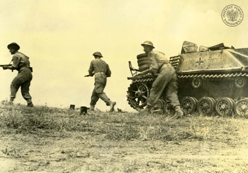 Polscy żołnierze piechoty mijają zniszczone niemieckie działo samobieżne (Sturmgeschütz III). Uzbrojeni są w amerykańskie pistolety maszynowe (11,43 mm Thompson M1A1), noszą brytyjskie mundury (tzw. battledress) i tak zwane hełmy Brodiego (Mk II). Rejon Ankony, lipiec 1944 roku