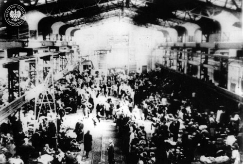 Hala fabryczna zamieniona w obóz dla wysiedlonych z Warszawy. Pruszków, sierpień 1944 r. (fot. z zasobu AIPN)