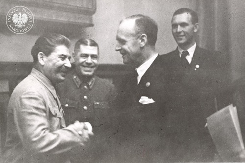Józef Stalin i minister spraw zagranicznych III Rzeszy Joachim von Ribbentrop wymieniają uścisk dłoni podczas uroczystego podpisania niemiecko-sowieckiego traktatu o granicach i przyjaźni (tzw. II paktu Ribbentrop-Mołotow) na Kremlu w Moskwie. Z tyłu szef Sztabu Generalnego Armii Czerwonej komandarm Borys Szaposznikow i członek niemieckiej delegacji, adiutant ministra Ribbentropa - Richard Schulze-Kossens (w klapie marynarki ma wpięty znaczek członka NSDAP). Zdjęcie ze zbioru kopii cyfrowych fot