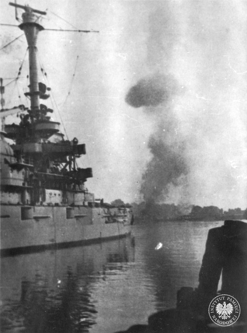 Niemiecki pancernik szkolny Schleswig-Holstein ostrzeliwuje polską placówkę (Wojskową Składnicę Tranzytową) na Westerplatte w Gdańsku, stojąc w poprzek kanału portowego. Gdańsk, 1 września 1939 roku
