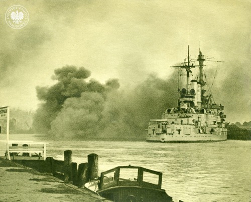Niemiecki pancernik szkolny Schleswig-Holstein ostrzeliwuje polską placówkę (Wojskową Składnicę Tranzytową) na Westerplatte w Gdańsku, stojąc w poprzek kanału portowego. Gdańsk, 1 września 1939 roku