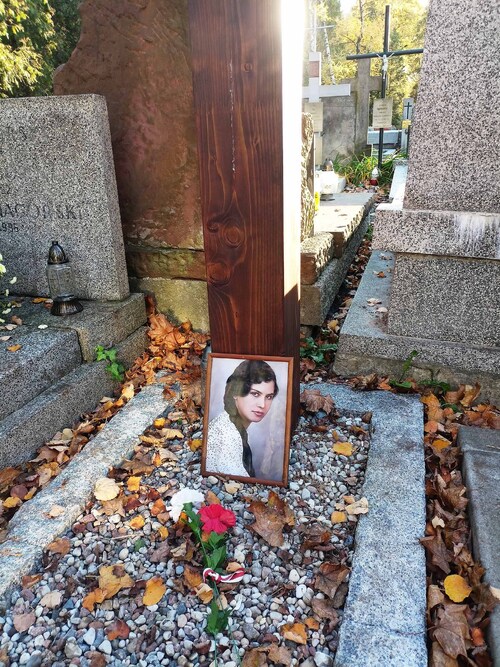 Zdjęcie Ewy Faryaszewskiej przy krzyżu nad symbolicznym grobem w kwaterze żołnierzy batalionu „Zośka” na warszawskich Powązkach Wojskowychh, 2024 r. (fot. K.M.)