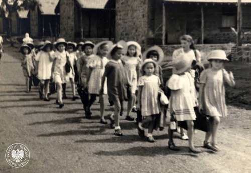 Przemarsz gromady zuchowej Świetliki z wodzem – Danutą Pniewską. Osiedle Polskie w Valivade, 1945–1947. Zdjęcie pochodzi z kolekcji przekazanej do zasobu Archiwum IPN przez pana Wiesława Stypułę