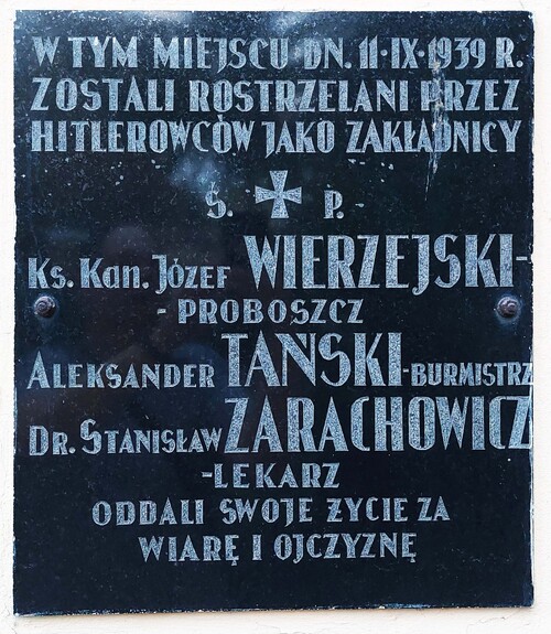 Tablica pamiątkowa na murze kościoła w miejscu gdzie rozstrzelano burmistrza Aleksandra Tańskiego, proboszcza ks. Józefa Wierzejskiego i lekarza Stanisława Zarachowicza. Mszczonów, 2025 r. (fot. P. Zielony)