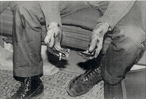 Ręce Adama Pohla w rękawiczkach gumowych z widocznymi zabrudzeniami od farby drukarskiej (fot. z zasobu IPN)