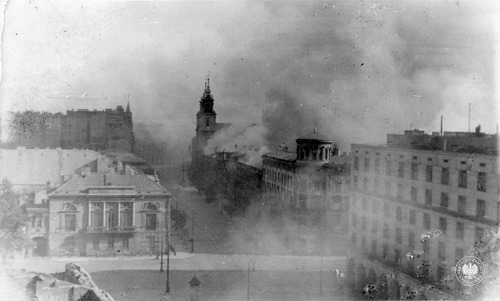 Płonące budynki przy ul. Krakowskie Przedmieście w Warszawie. Widok ogólny z Hotelu Bristol w stronę ul. Nowy Świat, w tle pośrodku zarysy Pałacu Staszica (fot. z zasobu AIPN)