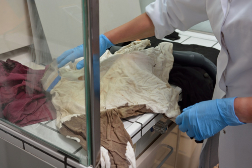 Sprawdzanie stanu zachowania ubrań ofiar Grudnia 1970. Fot. Archiwum IPN