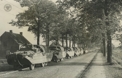 Kolumna pływających transporterów kołowych produkcji amerykańskiej DUKW (zw. „ducks” – „kaczki”) na trasie marszu 1. Dywizji Pancernej w czasie natarcia na Bredę (po zdobyciu 27 października 1944 r. miejscowości Alphen i Gilze). Odbitka rozpowszechniana przez komórki propagandy Rządu RP na uchodźstwie, pochodząca z kolekcji Teresy Mellerowicz-Gelli (fot. z zasobu AIPN)