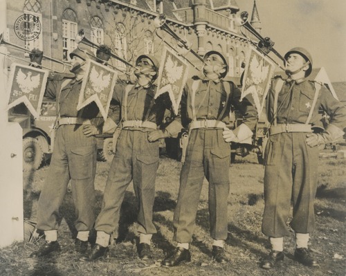 Polscy trębacze z 24. Pułku Ułanów 1. Dywizji Pancernej grają na trąbkach sygnalizacyjnych w zajętej Bredzie, październik-listopad 1944 r. Odbitka rozpowszechniana przez komórki propagandy Rządu RP na uchodźstwie, pochodząca z kolekcji Teresy Mellerowicz-Gelli (fot. z zasobu AIPN)
