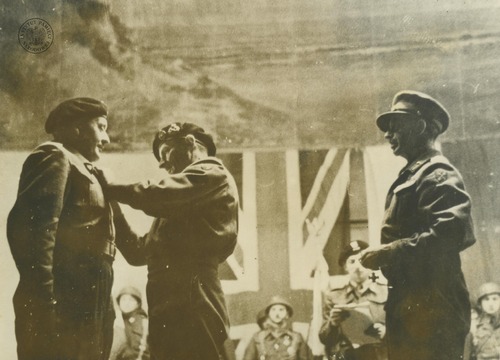 Dowódca 21. Grupy Armii marsz. polny Bernard Montgomery (drugi od lewej) przypina odznaczenie dowódcy polskiej 1. Dywizji Pancernej PSZ gen. bryg. Stan. Maczkowi. Breda, 25 listopada1944 r. Po prawej stoi najprawdopodobniej dowódca 1. Armii Kanadyjskiej gen. Henry „Harry” Crerar. Odbitka rozpowszechniana przez komórki propagandy Rządu RP na uchodźstwie, pochodząca z kolekcji Teresy Mellerowicz-Gelli (fot. z zasobu AIPN)