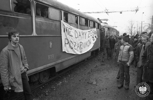 Akcja poparcia dla strajkujących w WOSP. Na transparencie wywieszonym na tramwaju widoczne hasło: „Nie damy zgasić pożarników”. Warszawa, 2 grudnia 1981 r. Fot. Jan Hausbrandt (fot. zasobu AIPN)
