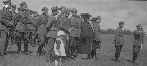 Inspektor Armii, gen. dyw. Edward Śmigły-Rydz w asyście oficerów Sztabu Głównego WP odbiera defiladę oddziału kawalerii, prawdopodobnie podczas manewrów (fotografia wykonana przed 1935 r.). Wśród oficerów sztabu widoczny ks. biskup Władysław Bandurski, w czarnym ornacie i kapeluszu. Cyfrowa kopia zdjęcia została przekazana do zasobu IPN przez Andrzeja Kapłańskiego (fot. z zasobu AIPN)