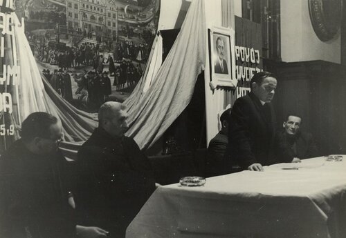 Zjazd działaczy katolickich i księży „patriotów” w Gdańsku, 14 grudnia 1950 r. Członkowie prezydium zebrania, w tym przewodniczący ks. Ambroży Dykier (stoi) i członek ks. Jan Cymanowski, wówczas proboszcz parafii na Emaus (drugi od lewej). Na ścianie portret Bolesława Bieruta i obraz Apoteoza Gdańska Izaaka van den Blocka z 1608 r. – jeszcze przed zamontowaniem na plafonie Wielkiej Sali Rady Ratusza Głównego Miasta (fot. z zasobu AIPN)