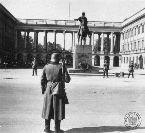 Niemieckie zdjęcie propagandowe przedstawiające posterunek Wehrmachtu przed Pałacem Saskim w Warszawie wkrótce po kapitulacji miasta. W głębi pomnik księcia Józefa Poniatowskiego, Pałac Saski i Grób Nieznanego Żołnierza. Warszawa, 30 września – 31 października 1939 r. Fot. Hugo Jäger (fot. z zasobu IPN)