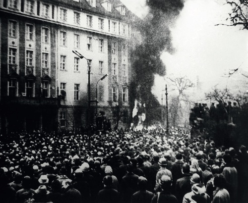 Robotnicy przed płonącym Komitetem Wojewódzkim PZPR w Gdańsku, 15 grudnia 1970 r. (fot. z zasobu AIPN)