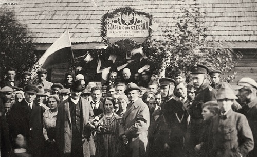 Wincenty Witos (z bukietem) na fotografii zbiorowej przed wejściem do Szkoły Powszechnej im. Kazimierza Promyka w Chodowie (fot. z zasobu AIPN)