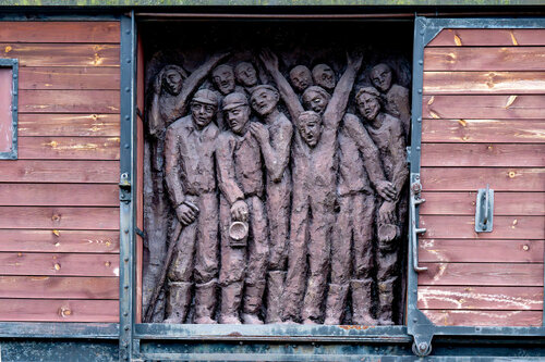 Pomnik Ofiar Tragedii Górnośląskiej w Bytomiu, centralny fragment. Poza rzeźbą przedstawiającą deportowanych górników ważną częścią monumentu jest tzw. krowiok, czyli jeden z wagonów bydlęcych, w jakich byli oni wywożeni do sowieckich łagrów po „wyzwoleniu” Górnego Śląska przez Armię Czerwoną (fot. IPN/Krzysztof Łojko)