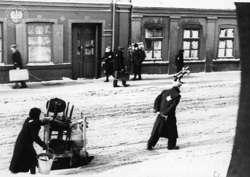Ludność żydowska transportująca swój dobytek podczas akcji zasiedlania getta – jedna z fotografii pochodzących z rękopisu Romana Zygadlewicza „Zawora”, żołnierza Okręgu Łódź AK. Autor opisał w nim życie w Łodzi pod okupacją niemiecką oraz działalność konspiracyjną ZWZ-AK. Łódź, ul. Franciszkańska (na wysokości nr. 26), luty 1940 r. (fot. z zasobu AIPN)