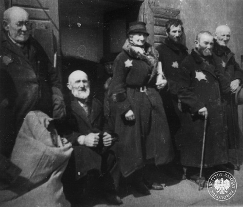 Grupa starców przed bramą na ulicy getta. Łódź, 1940–1942 r. (fot. z zasobu AIPN)