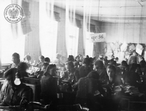 Sala w jednym z warsztatów krawieckich na terenie łódzkiego getta. Kobiety siedzą przy maszynach do szycia. Ogółem w getcie działało ponad 100 zakładów przemysłowych, produkujących m.in. bieliznę, mundury, czapki czy obuwie dla armii niemieckiej. Łódź, 1940–1942 r. (fot. z zasobu AIPN)