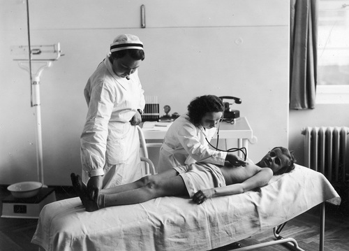 Lekarka w asyście pielęgniarki bada dziecko w gabinecie Dziecięcego Sanatorium Przeciwgruźliczego w Istebnej, 1937 r. (fot. z zasobu NAC)