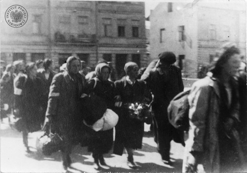 Wysiedlenie Żydów z getta krakowskiego do obozu pracy przymusowej w Płaszowie. Żydzi z walizkami, tobołkami opuszczają w pośpiechu plac Zgody (obecnie plac Bohaterów Getta). Marzec 1943 r. (fot. z zasobu AIPN)